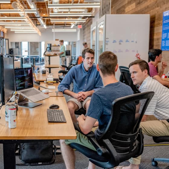 Pagoly team members collaborating at a computer in the office