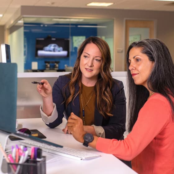 Two Pagoly team members reviewing a project at a computer